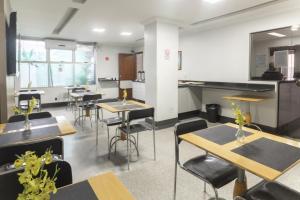 an empty room with tables and chairs in a cafeteria at Mangabeiras Hotel in Goiânia