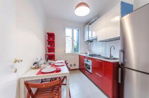 a kitchen with red cabinets and a refrigerator at Residenza Cavana in Venice