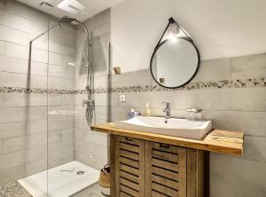 La salle de bains est pourvue d'un lavabo, d'une douche et d'un miroir. dans l'établissement La ferme de Pham, à Belberaud