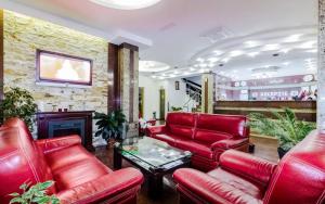 a lobby with red leather furniture and a fireplace at Hotel Bulevard in Făgăraş