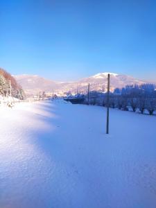 a snowy field with a pole in the snow at Котедж Shalet in Kolochava