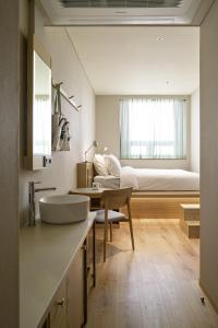 a bathroom with a sink and a bed in a room at HOTEL ANTEROOM SEOUL in Seoul