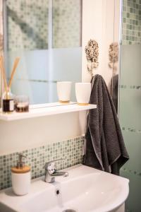 a bathroom sink with two cups on a shelf at la casetta in Sassari