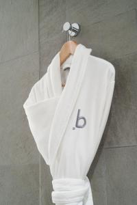 una sudadera blanca en una percha en una ducha en Bdesign & Spa en Paradou