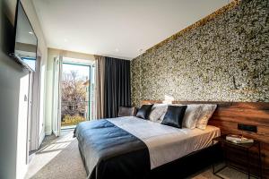 a bedroom with a large bed and a wall of wallpaper at Calma LUXURY Rooms in Split