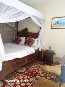 1 dormitorio con 1 cama con dosel en Machakos Suites Luxury Hotel, en Machakos