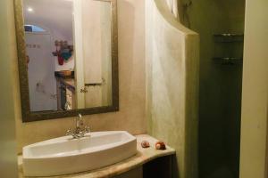 a bathroom with a sink and a mirror at Stefani Cave House Santorini in Firostefani