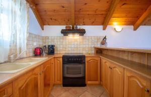eine Küche mit Holzschränken und einem Backofen mit schwarzem Kochfeld in der Unterkunft Psarou Studios in Ammoudi