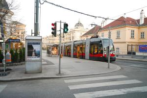 a tram on a city street with a traffic light at Premium Duplex 2BR for 6 with Balcony near City Museums Metro U3 U2 in Vienna +22 photos