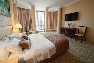 ヴヌーコヴォにあるRoyal Relaxing Spaの大型ベッド1台、薄型テレビが備わるホテルルームです。