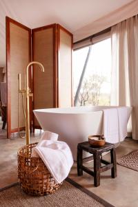 a bath tub in a bathroom with a large window at Thabamati Luxury Tented Camp in Timbavati Game Reserve