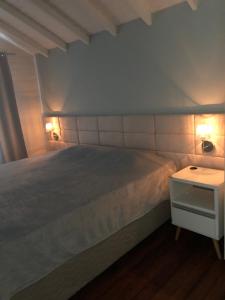 a bedroom with a bed with two lights on it at Casa para temporada in Florianópolis +26 photos