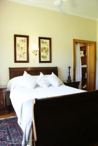 a bedroom with a large white bed with two pictures on the wall at Mieliefontein Karoo Guest Farm in Hanover Road