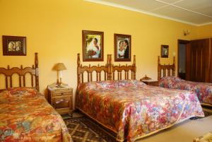 1 dormitorio con 2 camas en una habitación con paredes amarillas en Mieliefontein Karoo Guest Farm, en Hanover Road
