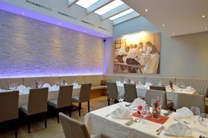 a restaurant with white tables and chairs and a large window at Wohlfühlhotel Schiestl in Fügen