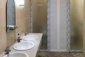 a bathroom with two sinks and a mirror at Wisma Syariah UINSU Medan Mitra RedDoorz in Medan