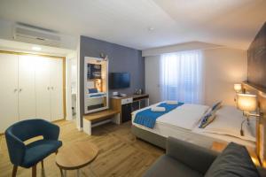 ein Hotelzimmer mit einem Bett und einem Sofa in der Unterkunft HOTEL IVANDO - K&S in Drvenik