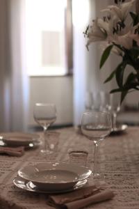 a table with a plate and two wine glasses on it at Casa Anna "a lovely home in Tuscany" in Colle di Val d'Elsa