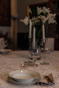 una mesa con un plato y dos vasos y velas en Casa Anna "a lovely home in Tuscany", en Colle Val D'Elsa