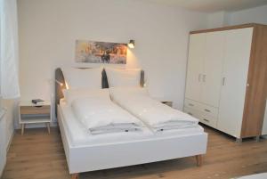 ein weißes Bett mit weißen Kissen im Schlafzimmer in der Unterkunft Ferienwohnung Finja in Bad Dürrheim