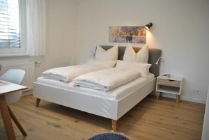 a bed with white sheets and pillows in a room at Ferienwohnung Finja in Bad Dürrheim