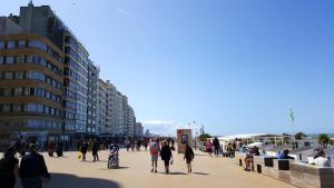 オーステンデにある2 bedrooms apartement at Oostende 500 m away from the beach with balconyの建物のある歩道を歩く人々