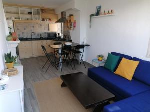 a living room with a blue couch and a kitchen at casal do melro in Ericeira