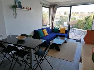a living room with a blue couch and a table at casal do melro in Ericeira