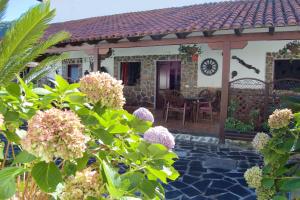 eine Terrasse eines Hauses mit einem Tisch und Blumen in der Unterkunft Charming Apartment in Los Silos, 80m² with Terrace in Los Silos