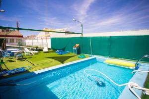 a large swimming pool with a green privacy fence at 3 bedrooms villa with private pool furnished terrace and wifi at Vitigudino in Vitigudino