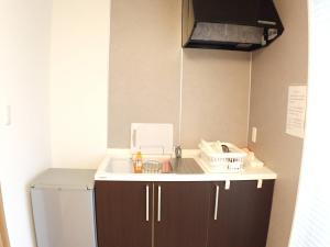 a kitchen with a sink and a refrigerator at Field Hakone Resort in Hakone