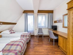 a hotel room with two beds and a desk at Dom Wypoczynkowy U Chramca in Białka Tatrzańska