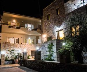 a large stone building at night with lights at Bonos apartments in Stoupa