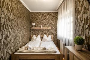 - une chambre avec un lit dans une pièce avec un mur dans l'établissement MF Club 218 Golden Beach Wellness Apartment, à Siófok