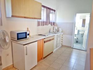a small kitchen with a microwave and a sink at Apartments Nada in Starigrad-Paklenica