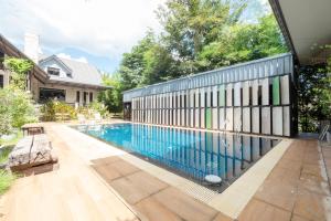 a swimming pool with a fence next to a house at Capital O 75378 Thawapee Resort in Rayong