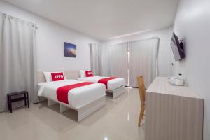 a hotel room with two beds and a table at Capital O 75378 Thawapee Resort in Rayong