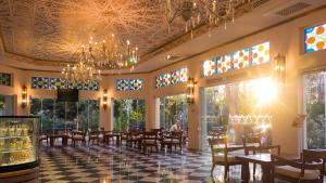 a restaurant with tables and chairs and a chandelier at Ali Bey Resort Sorgun in Side