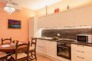 a kitchen with white cabinets and a table and a dining room at Tramonto sul Lago in Passignano sul Trasimeno