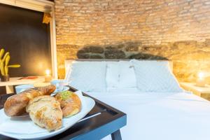 a plate of bread and croissants on a bed at Ice Queen Chamber by Rent All Como in Como