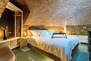 - une chambre avec un lit et un mur en briques dans l'établissement Ice Queen Chamber by Rent All Como, à Côme
