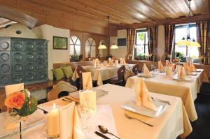a restaurant with white tables and chairs with flowers on them at Hotel-Gasthof Rangau in Ansbach