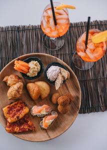 a wooden plate with food on a table with drinks at Mami Sabaudia Hotel in Sabaudia