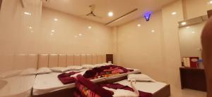 a room with three beds in a room with at Ashiyana Inn Hotel in Ajmer