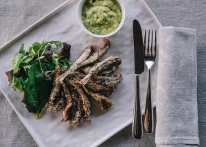 a plate of food with a salad and a bowl of dips at Mami Sabaudia Hotel in Sabaudia