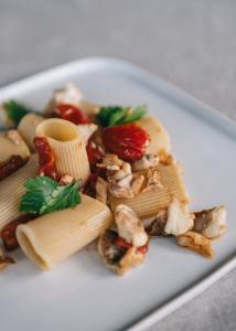 a white plate of food with pasta and vegetables at Mami Sabaudia Hotel in Sabaudia