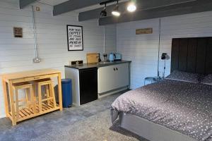 Zimmer mit einem Bett und einer Küche mit einer Theke in der Unterkunft Cosy, Self-Contained Garden Room in City Centre! in Hereford