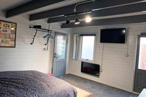 1 dormitorio con 1 cama y TV de pantalla plana en Cosy, Self-Contained Garden Room in City Centre!, en Hereford