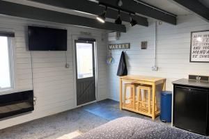 a room with a door and a table and a television at Cosy, Self-Contained Garden Room in City Centre! in Hereford +9 photos