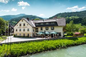 a hotel with a river in front of it at Landgasthof Bierfriedl in Pruggern